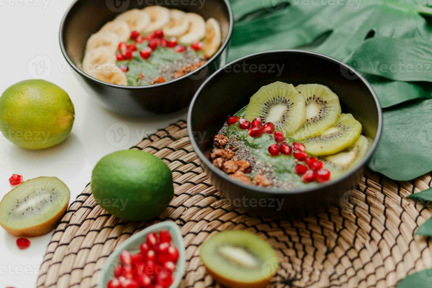 essentiel pour cuisine smoothie bol. blake assiette surmonté avec kiwi, banane, Grenade graines, chaux, granola, chia graines. en bonne santé petit déjeuner. tropical ambiance. photo