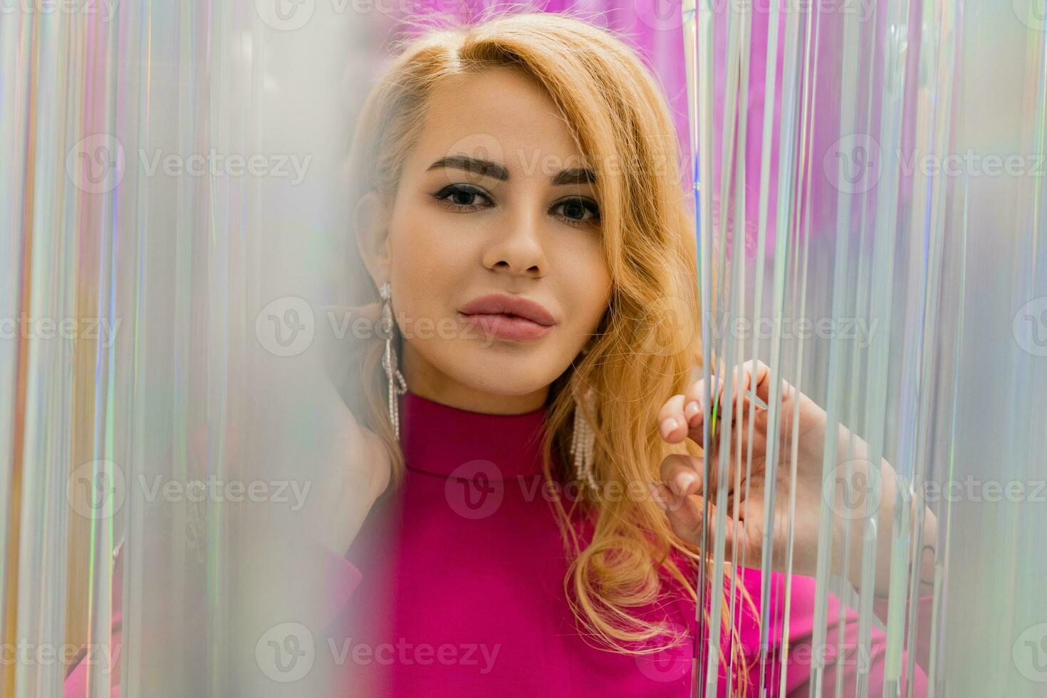 studio photo de brillant blond femme dans sexy rose robe. parfait ondulé Cheveux. Nouveau année faire la fête.
