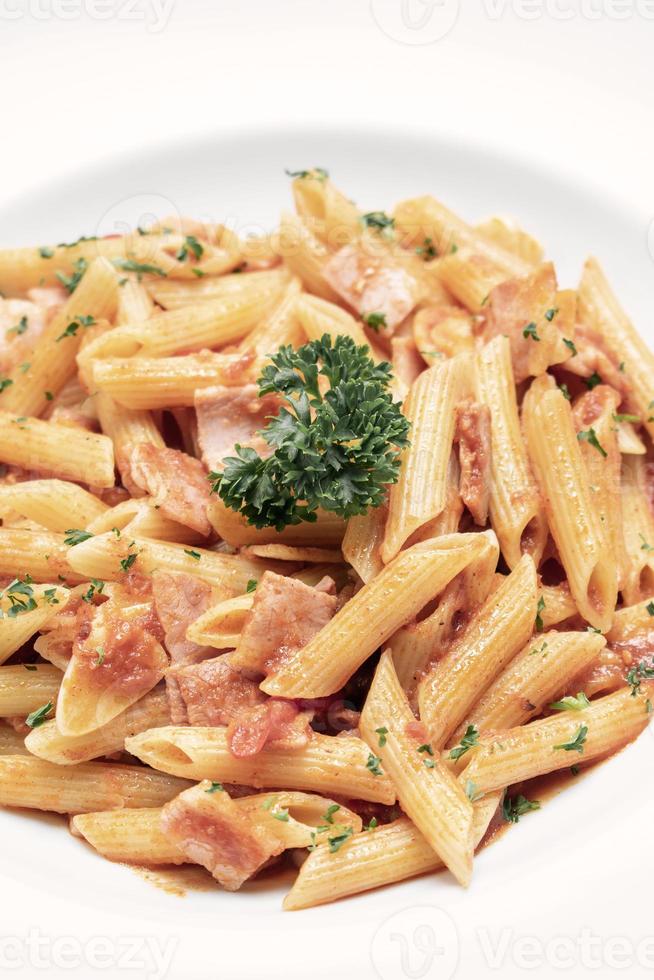 Penne amatriciana plat de pâtes sauce tomate et jambon bio sur tableau blanc photo