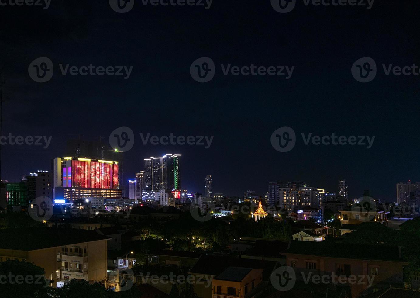 Vue de nuit sur la ville de phnom penh au centre-ville au cambodge avec le complexe de casino naga world et les toits de l'île de diamant de koh pich photo