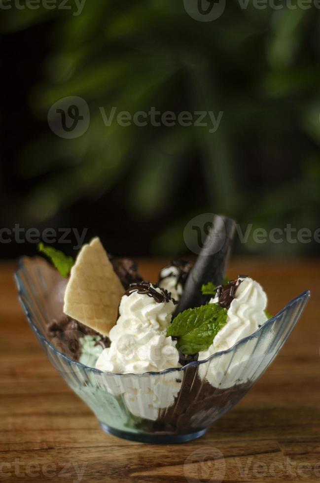 dessert sundae à la crème glacée biologique fraîche au chocolat et à la menthe sur une table en bois photo