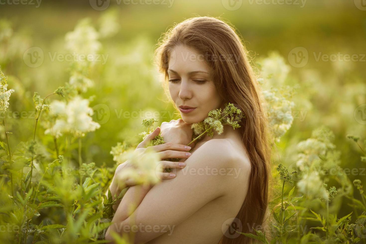 belle femme debout dans les hautes fleurs sauvages photo