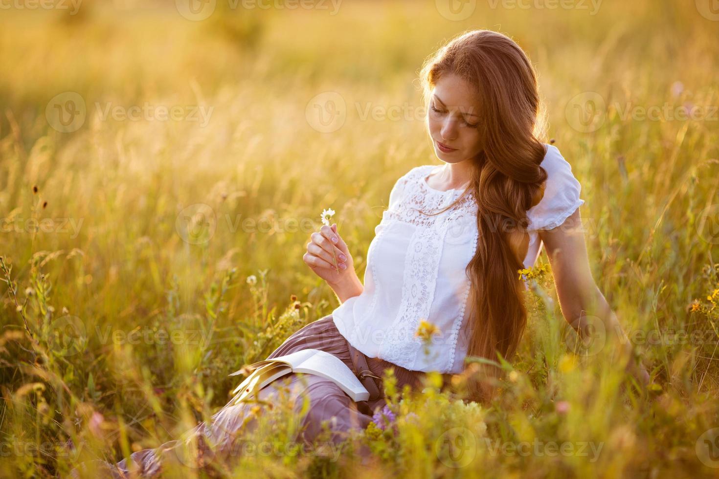 fille heureuse assise et lisant un livre photo