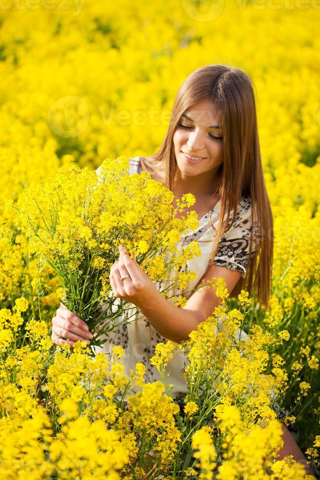 fille rassemble un bouquet de fleurs sauvages jaunes photo