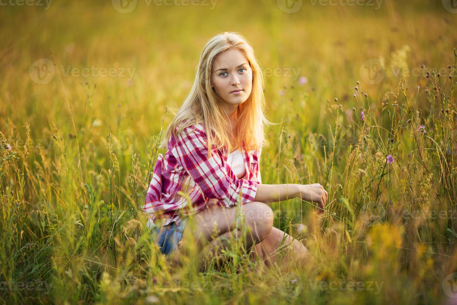 belle fille est assise dans l'herbe photo