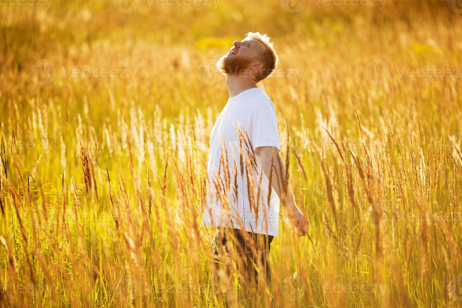 l'homme heureux se tient parmi l'herbe des prés photo