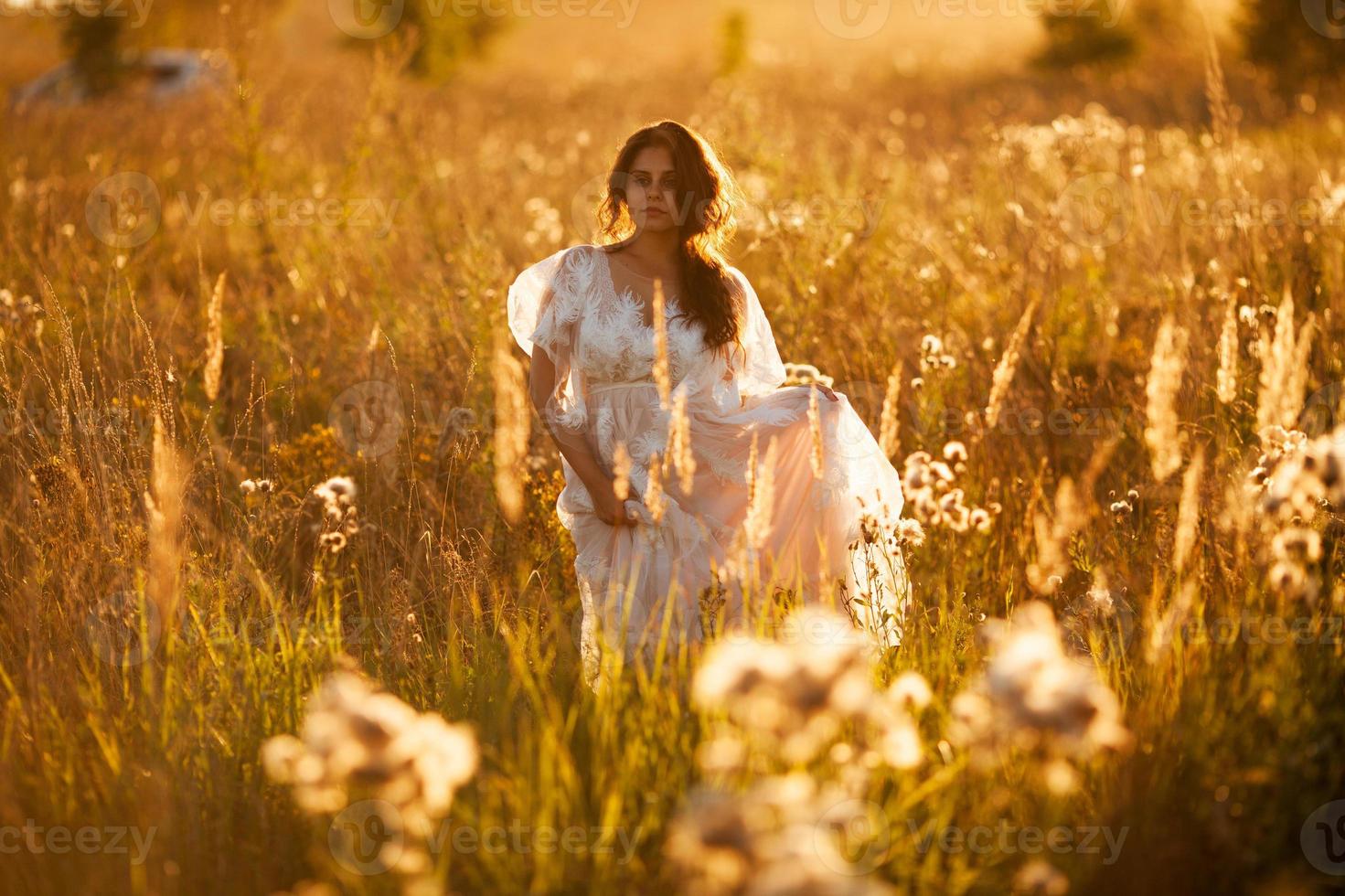 la mariée marche dans le pré photo