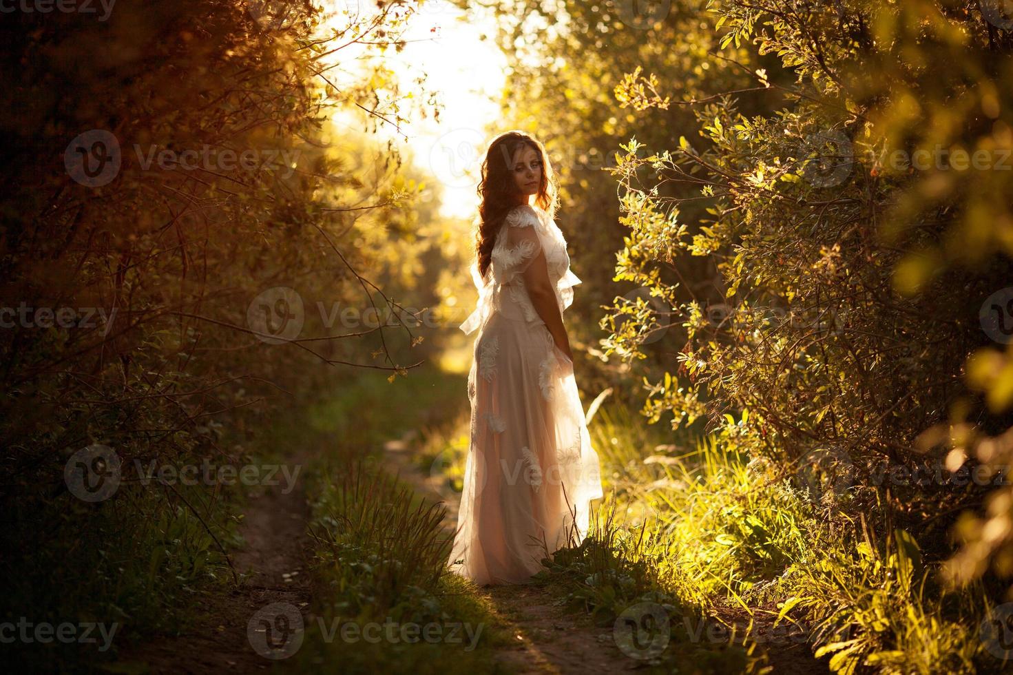 jeune femme vêtue d'une robe au coucher du soleil photo