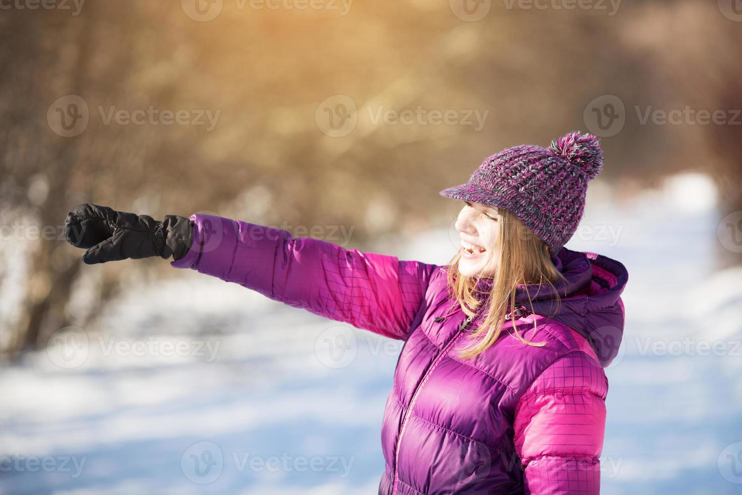 une fille heureuse pointe la main au loin photo