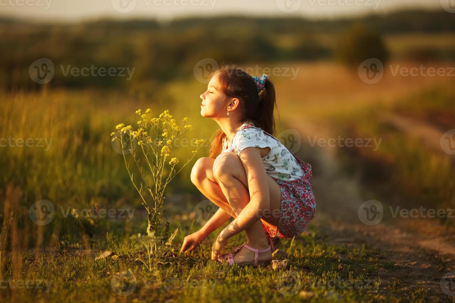 une fille respire l'arôme d'une fleur sauvage photo