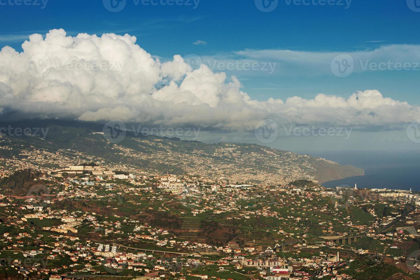 énorme nuage suspendu au-dessus de la ville sur une montagne photo