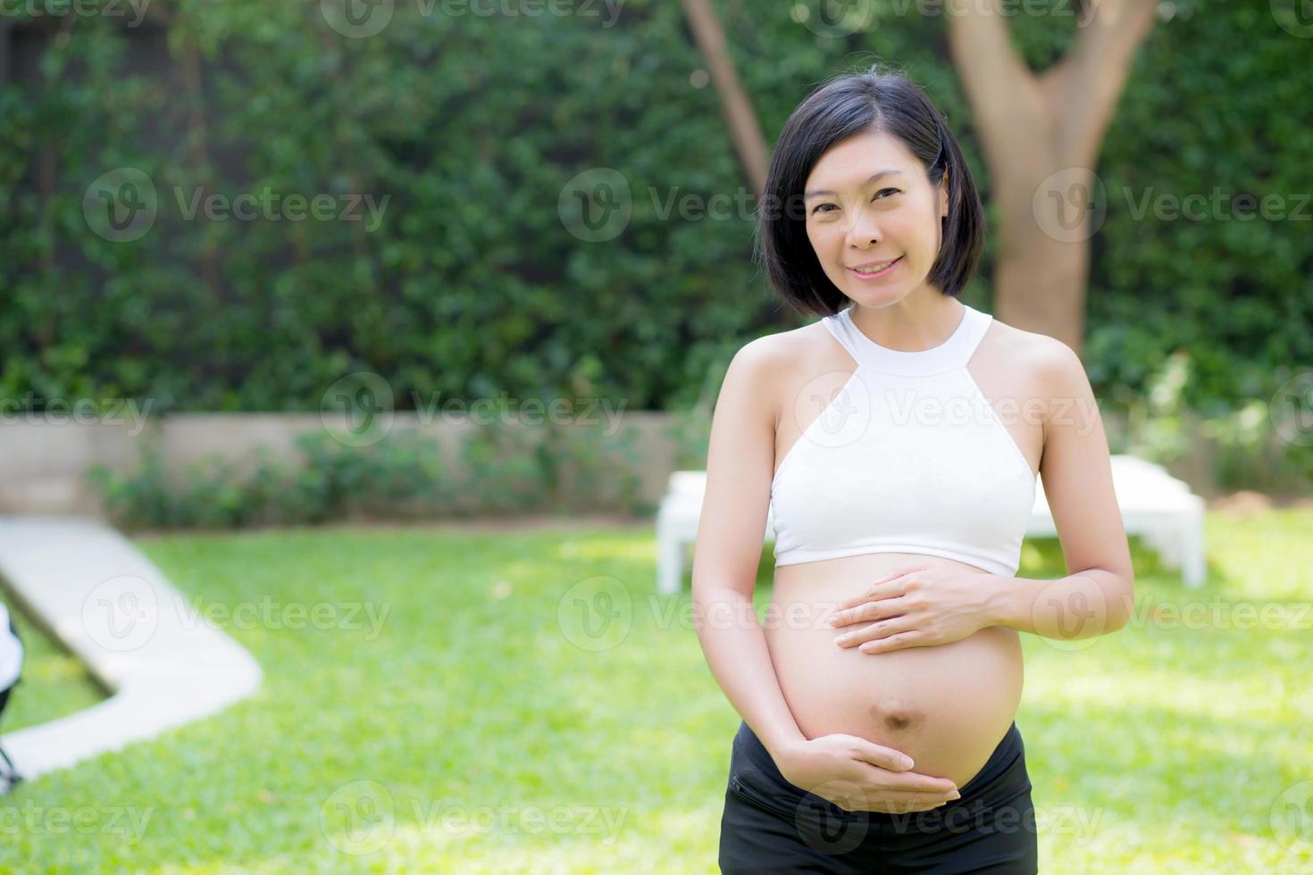 enceinte de portrait jeune femme asiatique se détendre dans le parc. photo