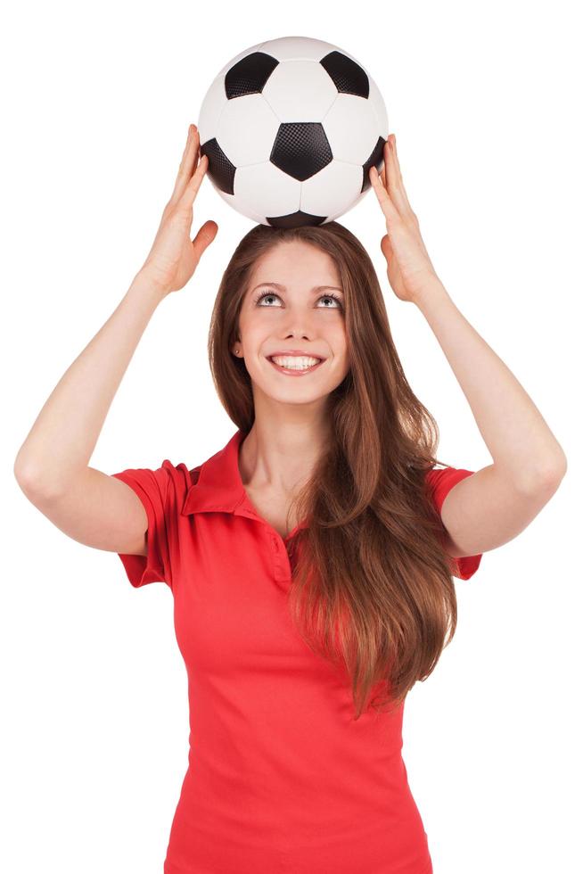 fille tenant un ballon de football sur la tête photo