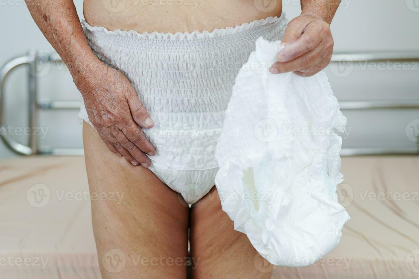 asiatique Sénior femme patient portant adulte incontinence couche tampon dans hôpital. photo