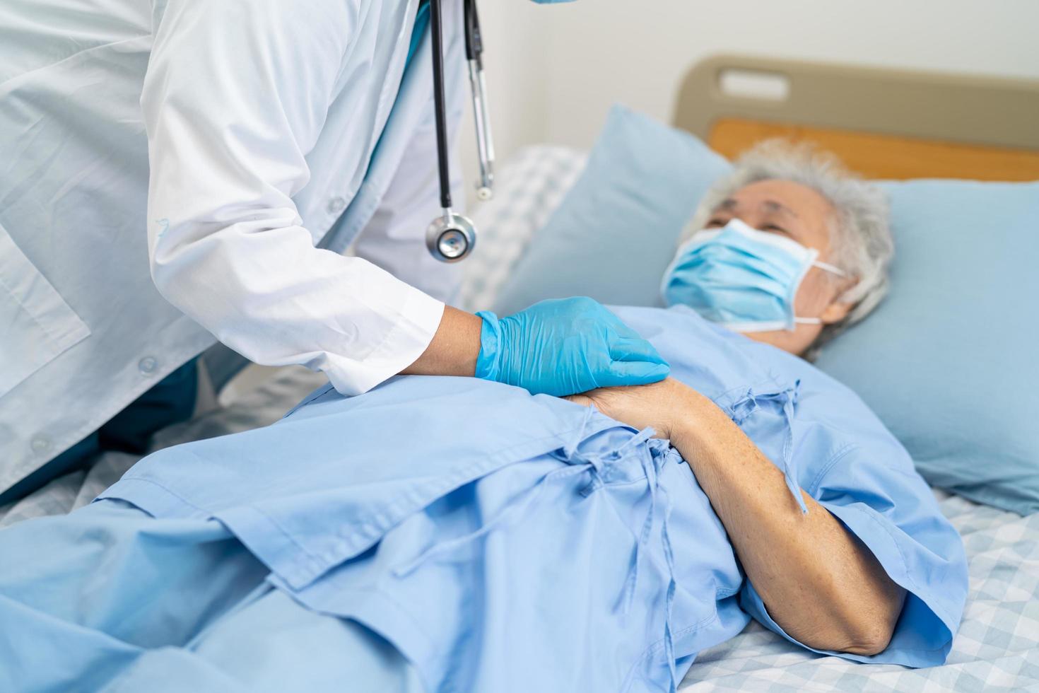 un médecin aide un patient asiatique âgé portant un masque pour protéger le coronavirus. photo