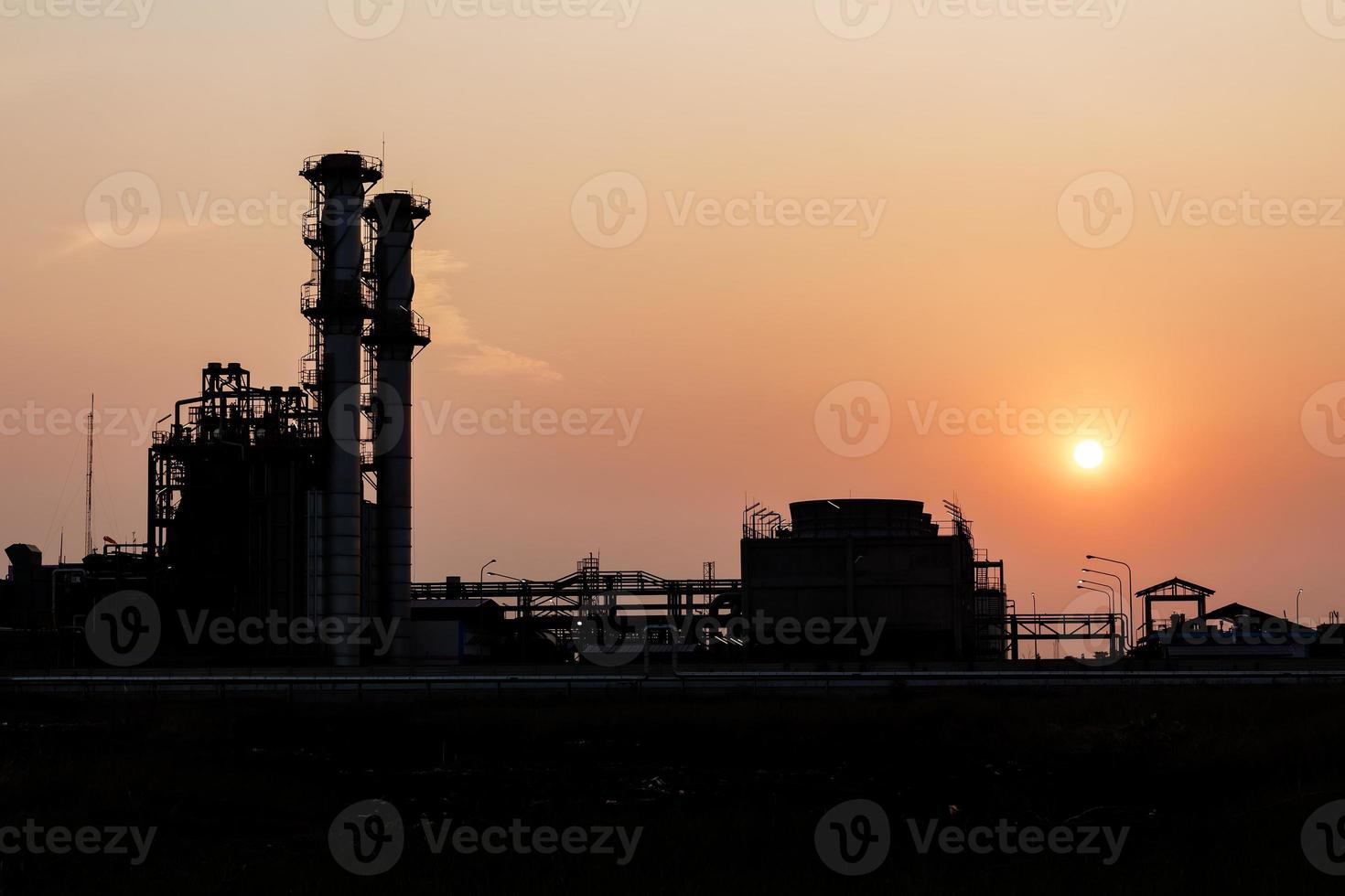 silhouette de tours de distillation au coucher du soleil photo
