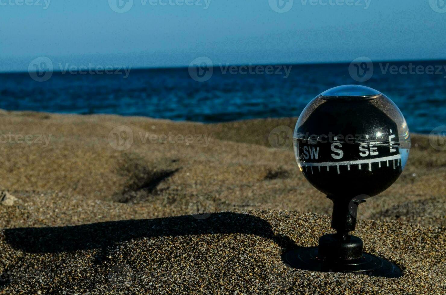 une boussole sur le plage avec le océan dans le Contexte photo