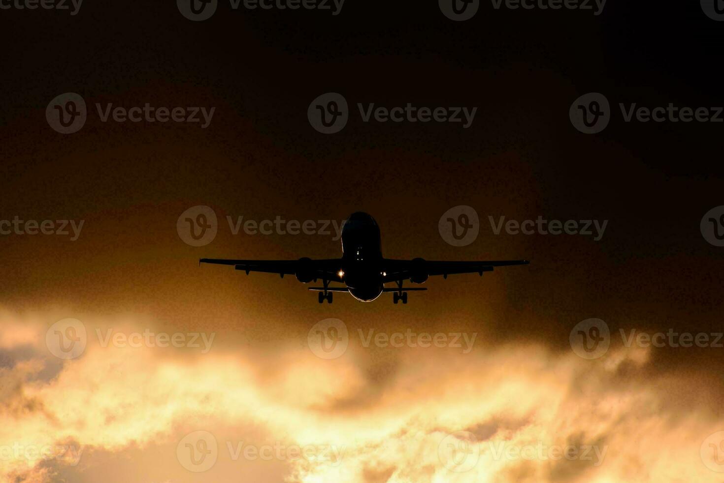 une avion en volant par le des nuages à le coucher du soleil photo