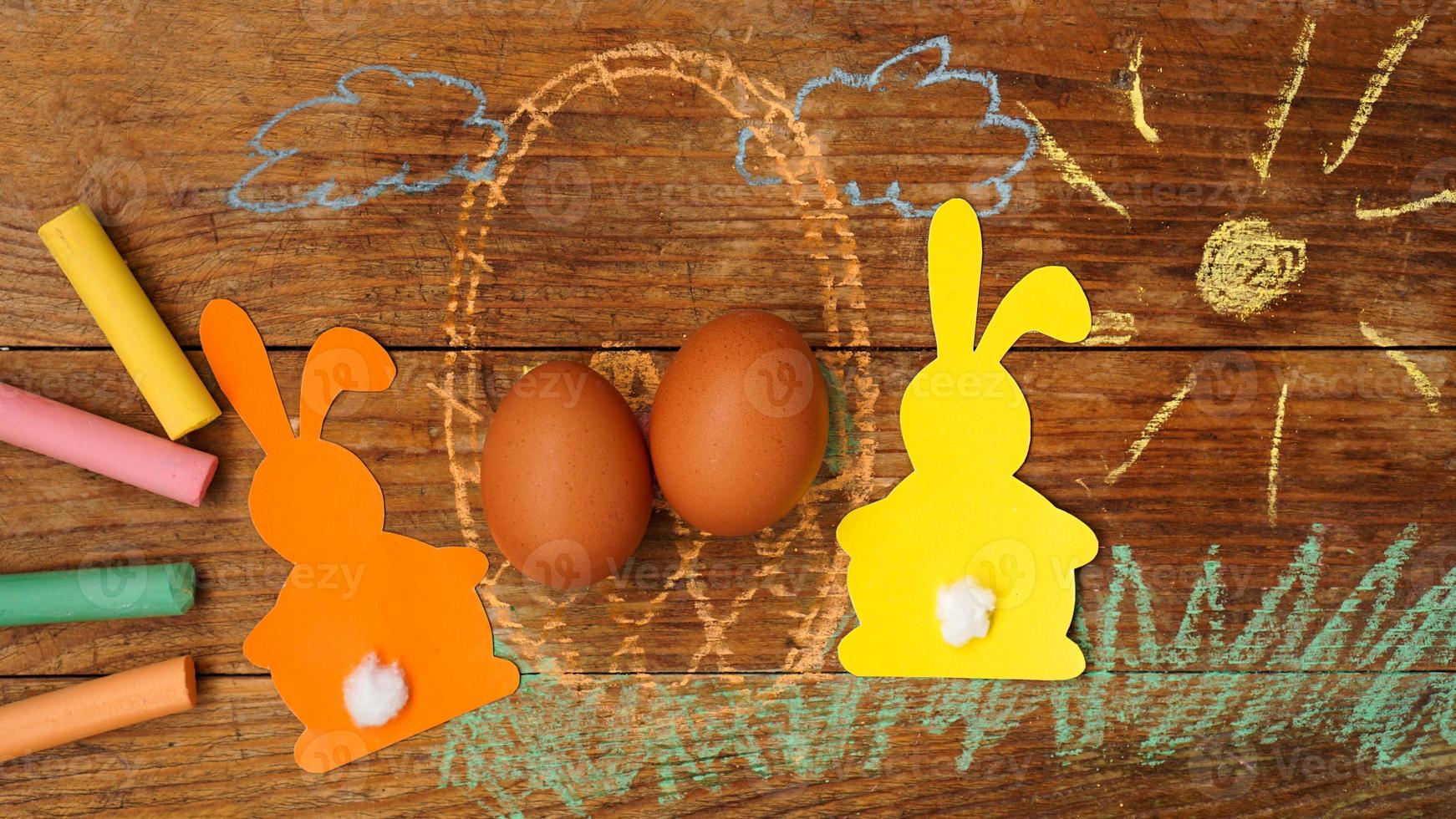 deux lapins de pâques en papier et œufs dans un panier. photo