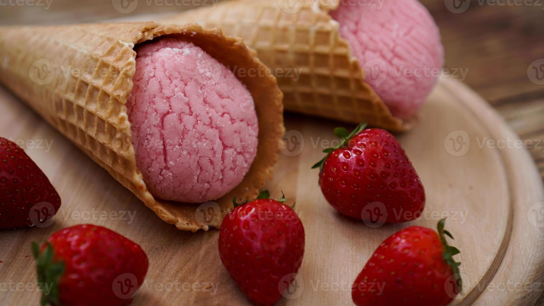 glace à la fraise dans un cornet gaufré. fruits rouges et boules de glace photo