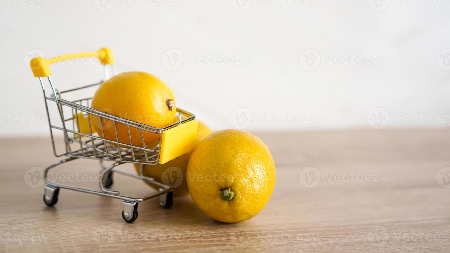 citron dans un chariot de supermarché sur fond de cuisine photo