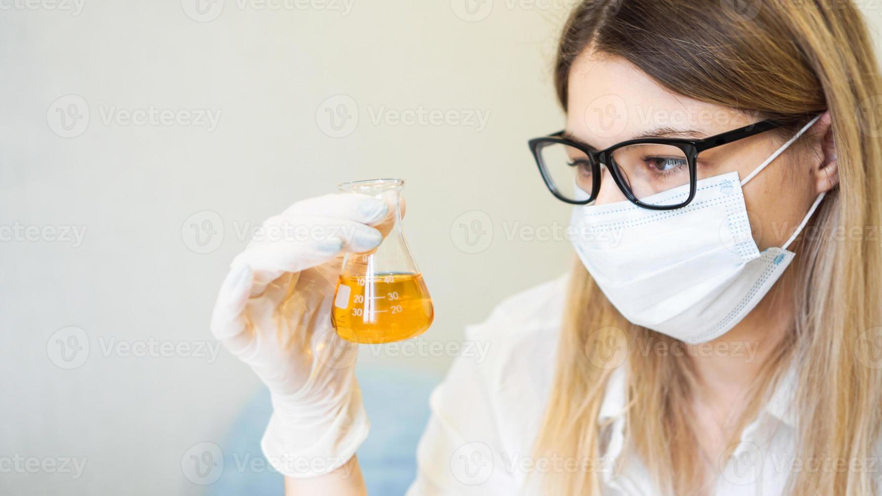 une femme tient une fiole avec un test d'urine photo