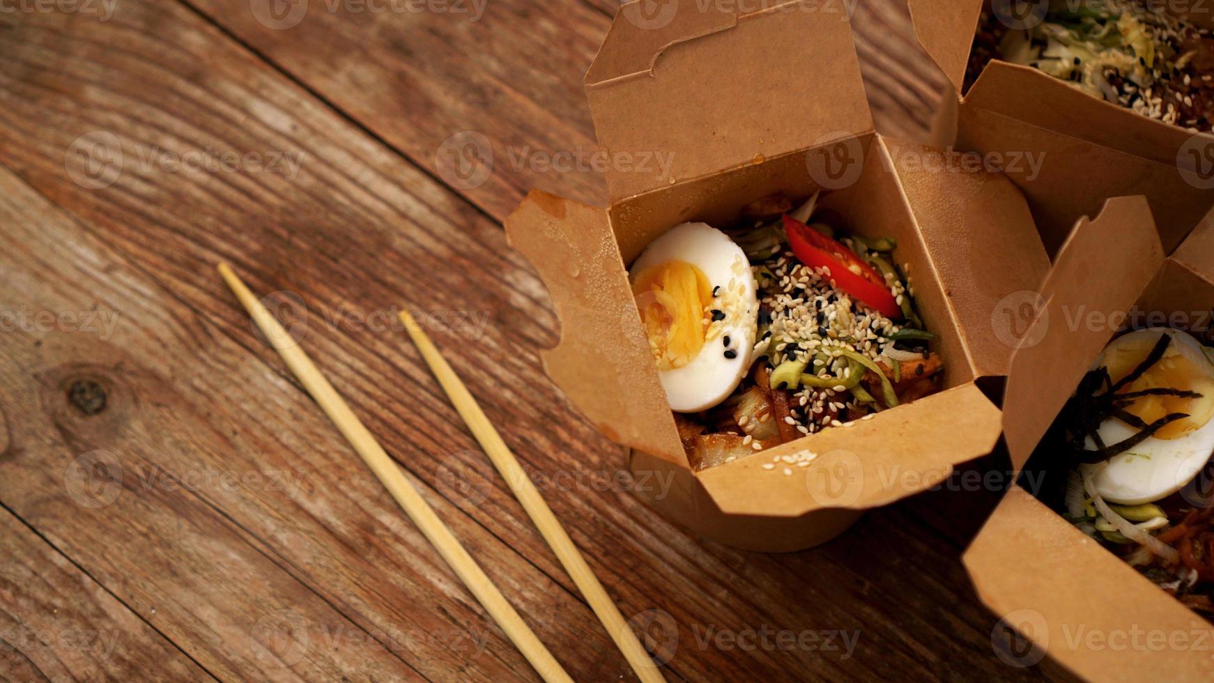 nouilles chinoises au poulet dans des boîtes en carton sur fond de bois photo