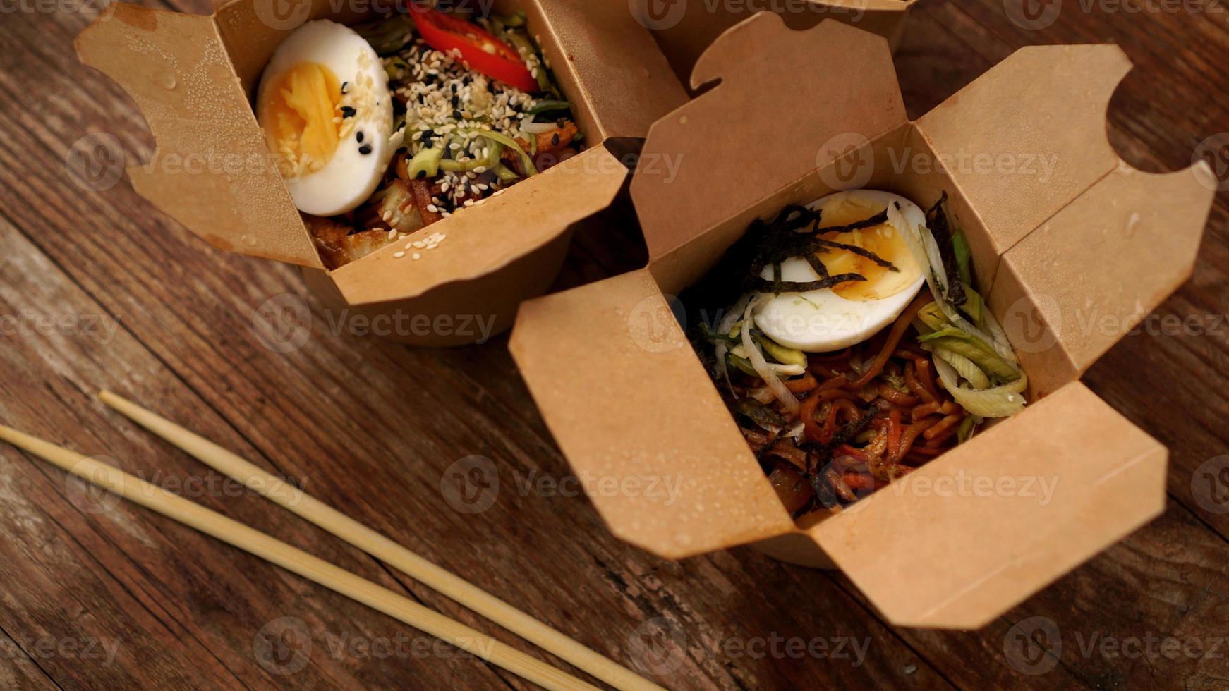 nouilles chinoises au poulet dans des boîtes en carton sur fond de bois photo