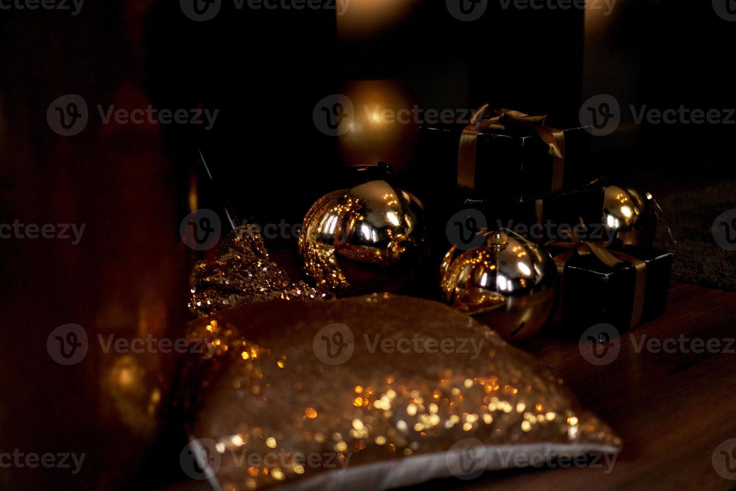 coffret cadeau noir avec ruban doré et grosses boules dorées du nouvel an sur fond noir photo