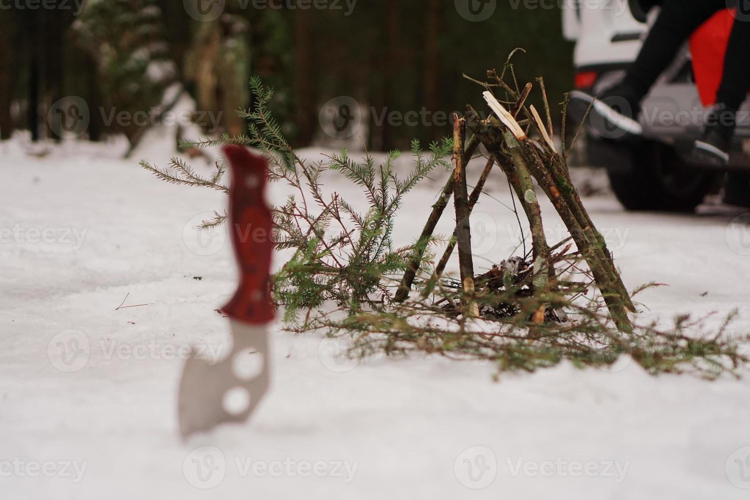 couteau touristique et feu de joie dans la forêt d'hiver. photo