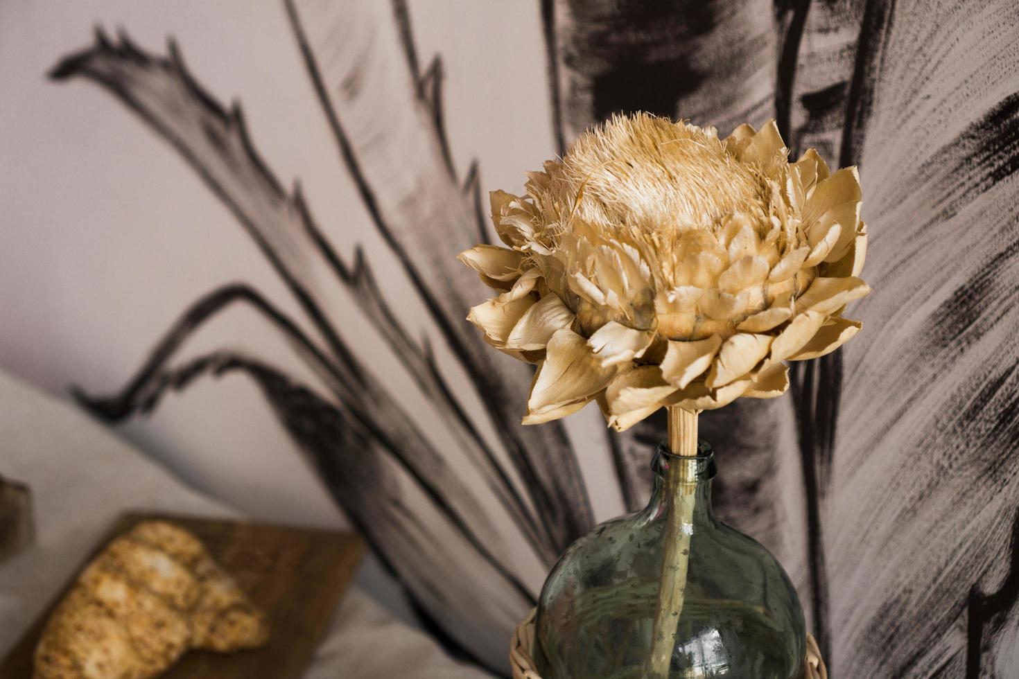 fleur séchée dans un bocal en verre sur fond gris photo