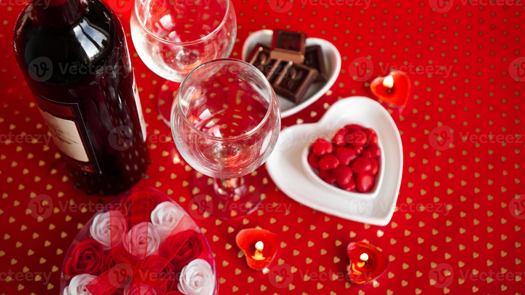 La Saint-Valentin. bouteille de vigne, verres, roses rouges photo