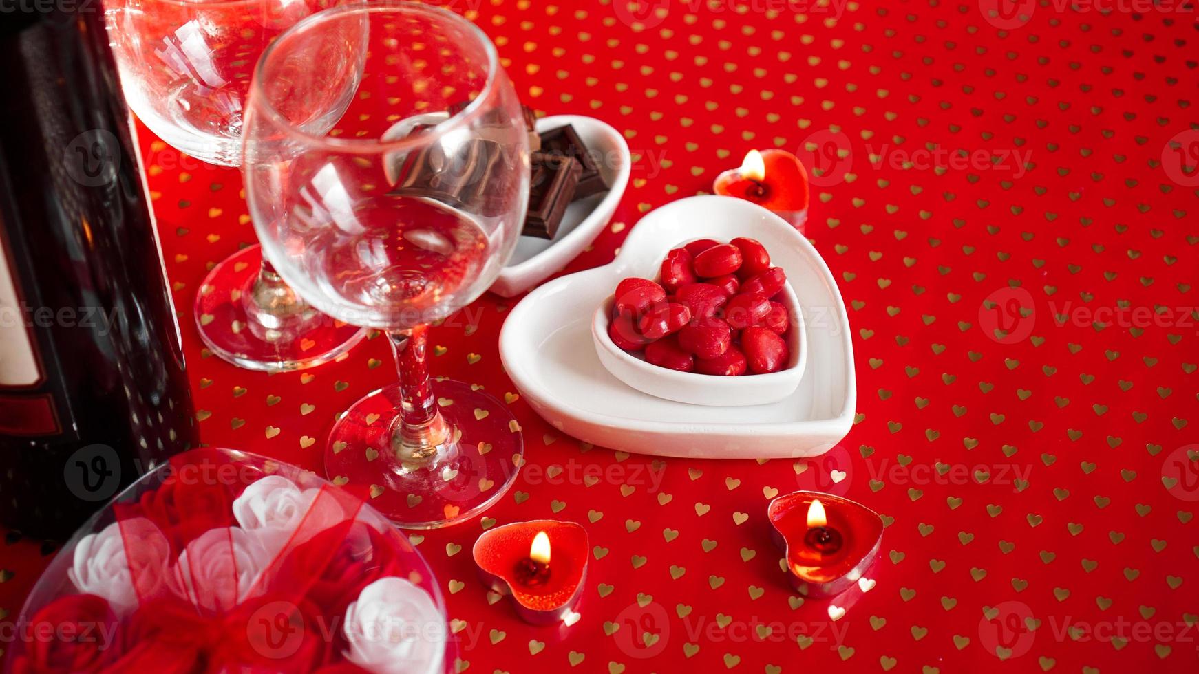 La Saint-Valentin. bouteille de vigne, verres, roses rouges photo