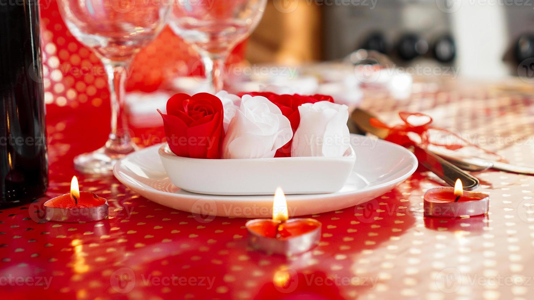 La Saint-Valentin. bouteille de vigne, verres, roses rouges photo