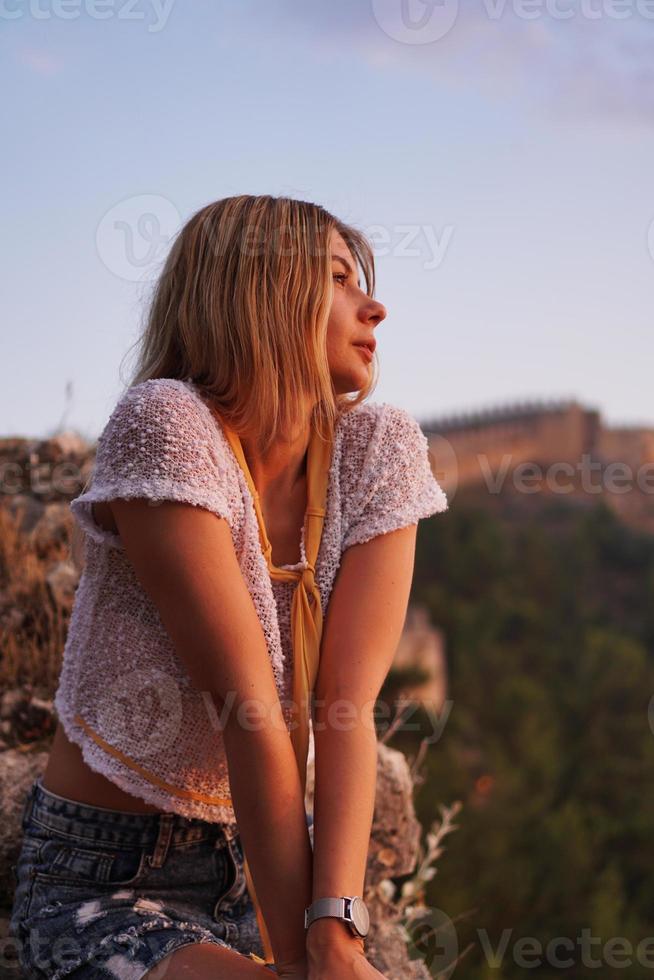 belle fille au coucher du soleil. ancien château en arrière-plan photo