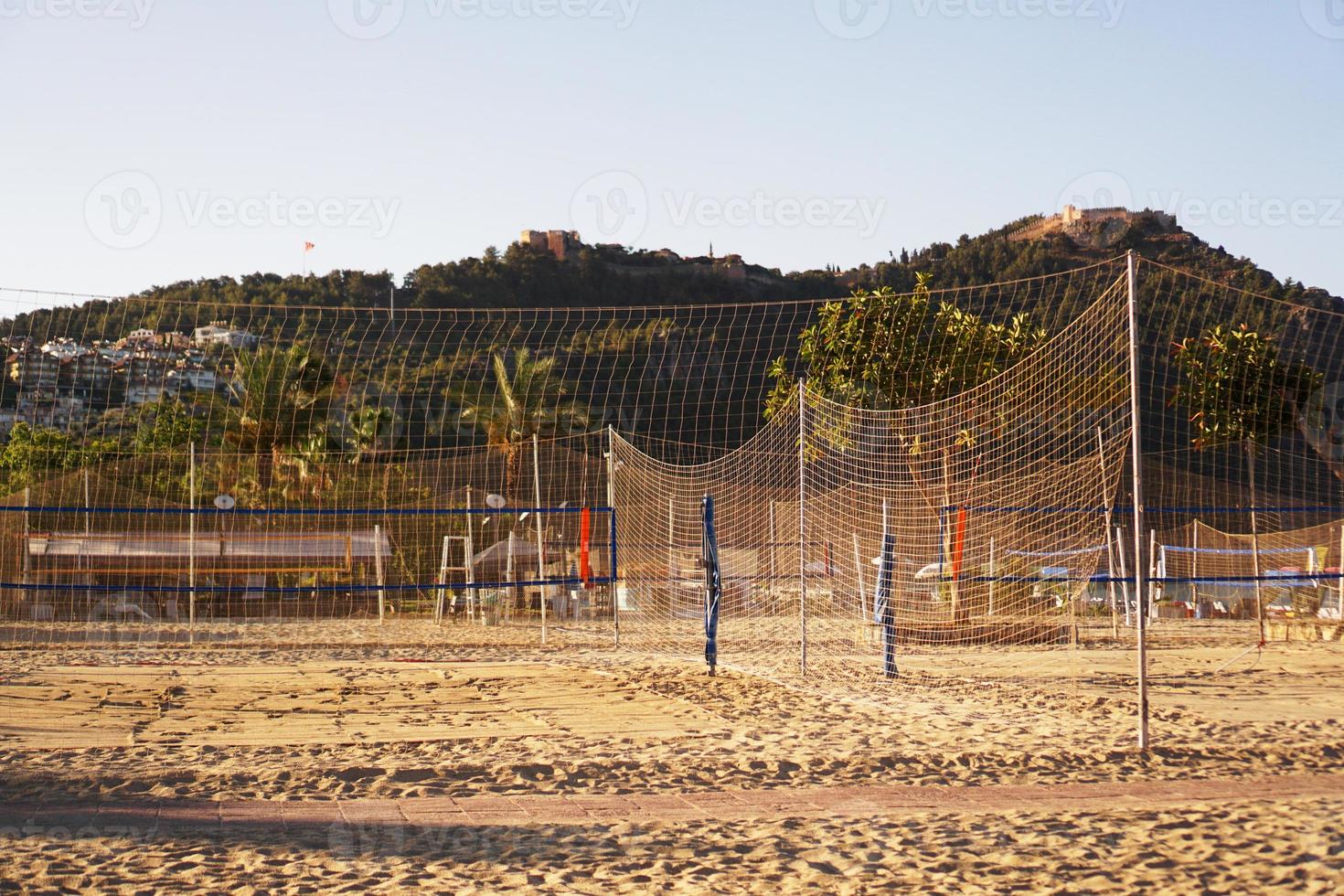 terrain de volley-ball sur la plage d'alanya, en turquie. palmiers et montagnes photo