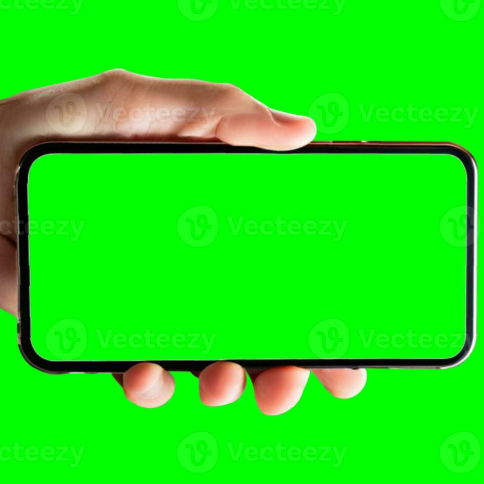 image de main en portant une téléphone avec une vert écran dans paysage orientation. sur une blanc Contexte. photo