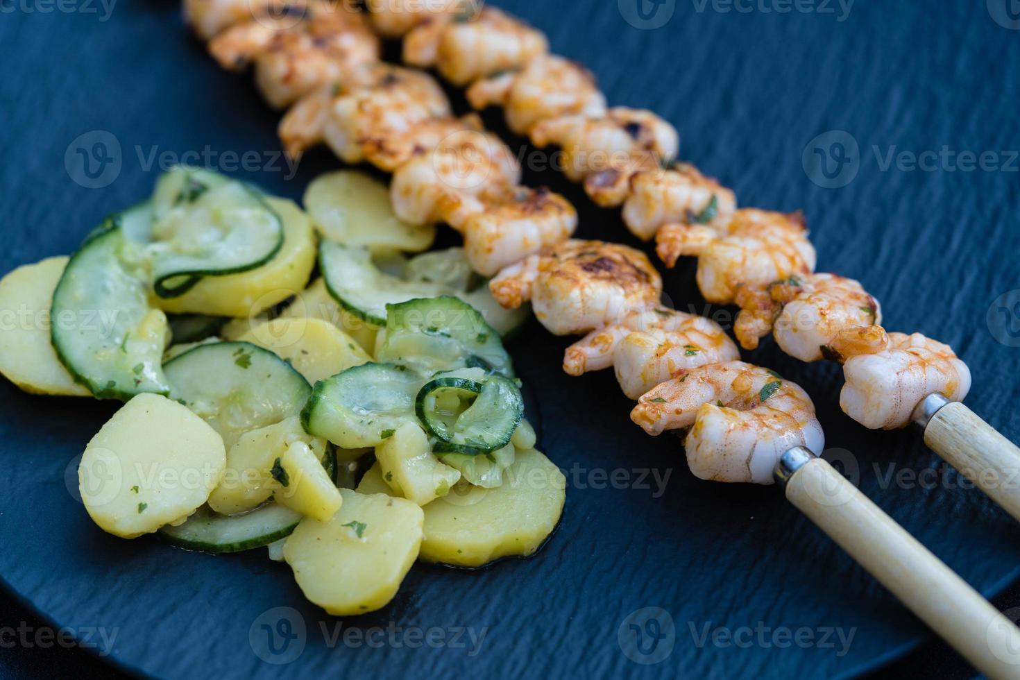 crevettes tigrées blanches épicées grillées avec salade de pommes de terre et de concombre photo