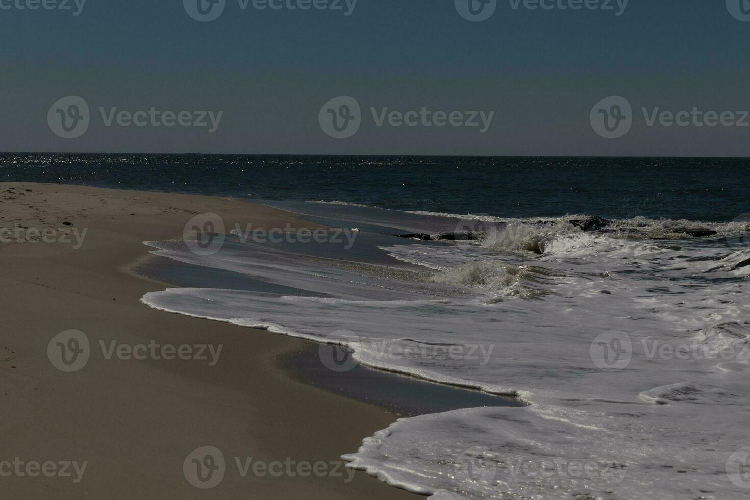 je aimé le Regardez de cette plage scène comme le vagues écrasé dans. le jolie Regardez de le à tête blanche le surf se précipiter dans à le rive. le le sable montrant une différent Ton à où le l'eau une fois était. photo
