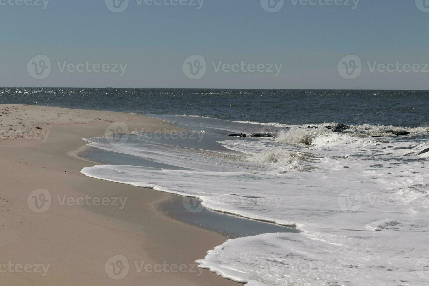 je aimé le Regardez de cette plage scène comme le vagues écrasé dans. le jolie Regardez de le à tête blanche le surf se précipiter dans à le rive. le le sable montrant une différent Ton à où le l'eau une fois était. photo