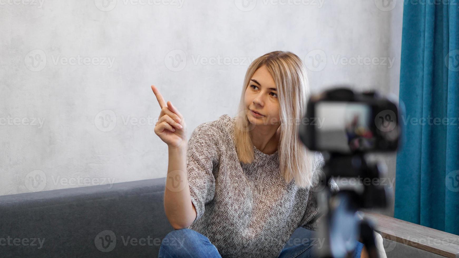 la femme montre avec sur un mur gris. lieu d'information photo