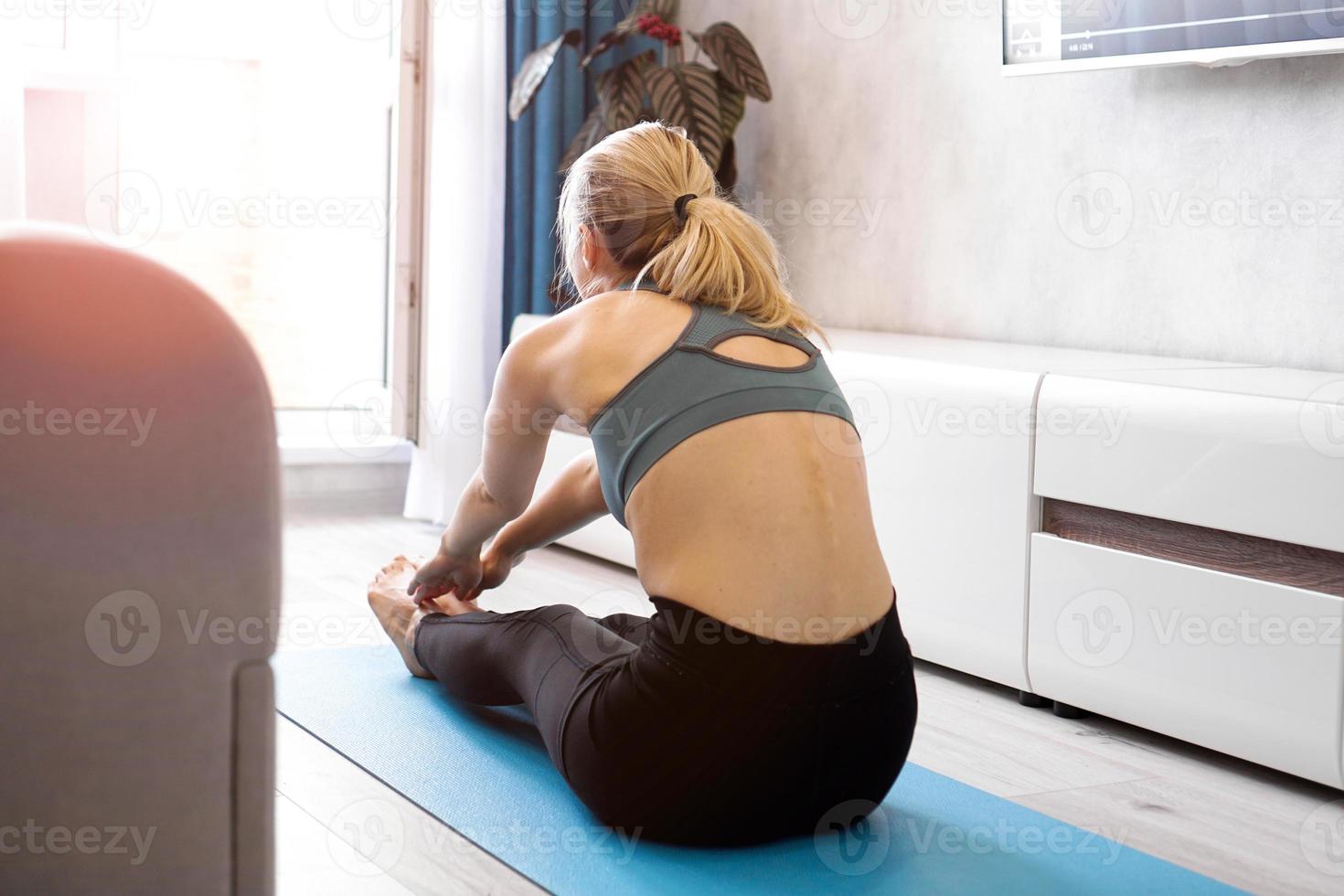 femme de remise en forme qui s'étend des jambes à la maison photo