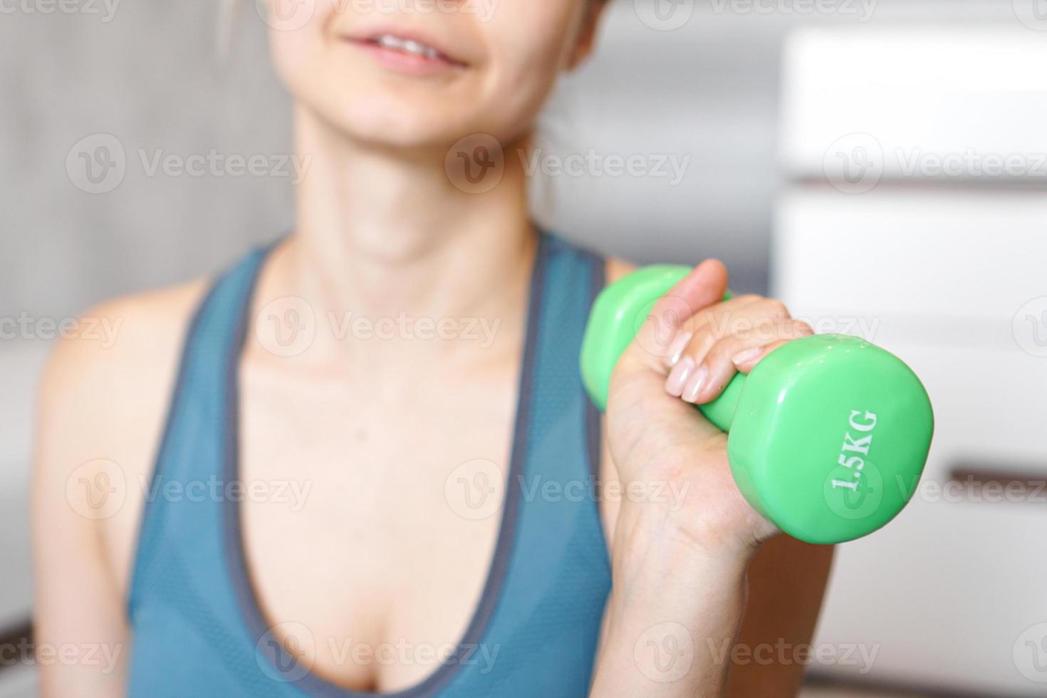 concept de sport et de loisirs - main de femme sportive avec haltère vert photo