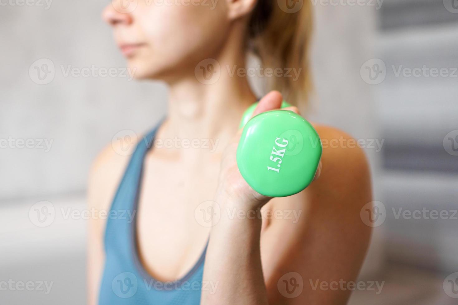 concept de sport et de loisirs - main de femme sportive avec haltère vert photo