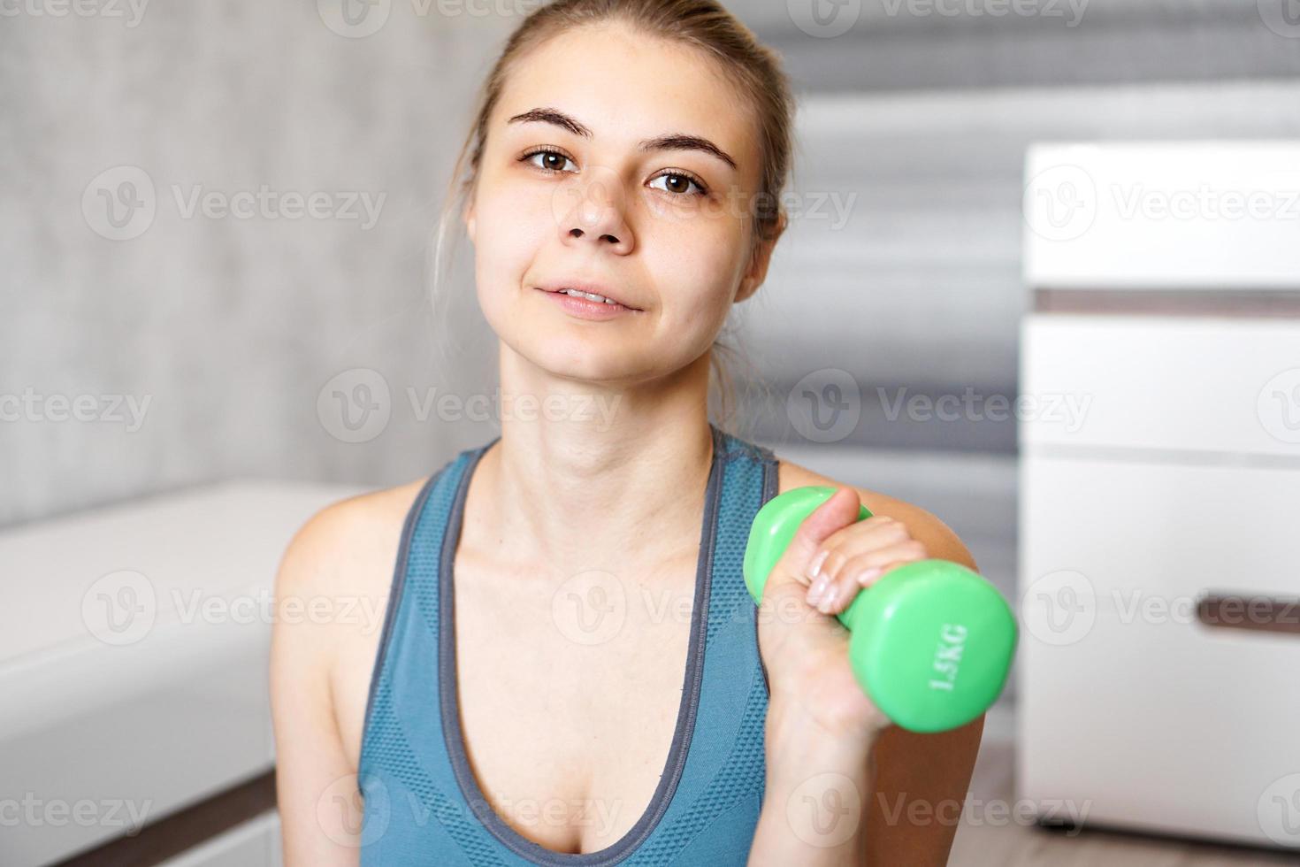 portrait d'une femme qui tient un haltère dans ses mains photo