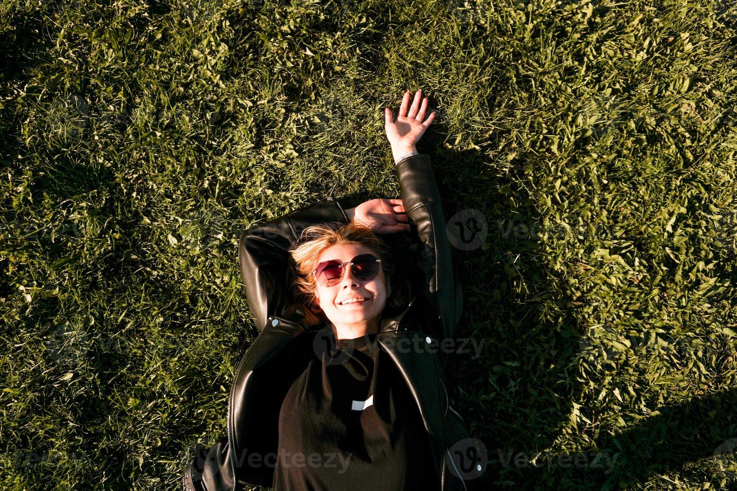 belle jeune femme en bonne santé allongée et relaxante sur l'herbe verte photo