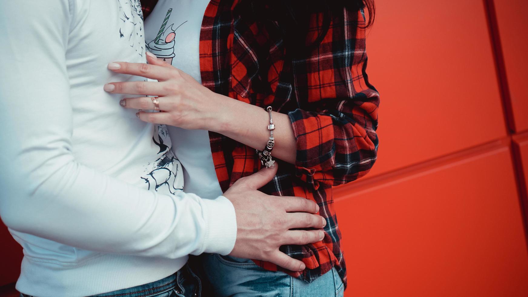 couple datant et étreignant dans l'amour dans une journée ensoleillée - fond rouge photo