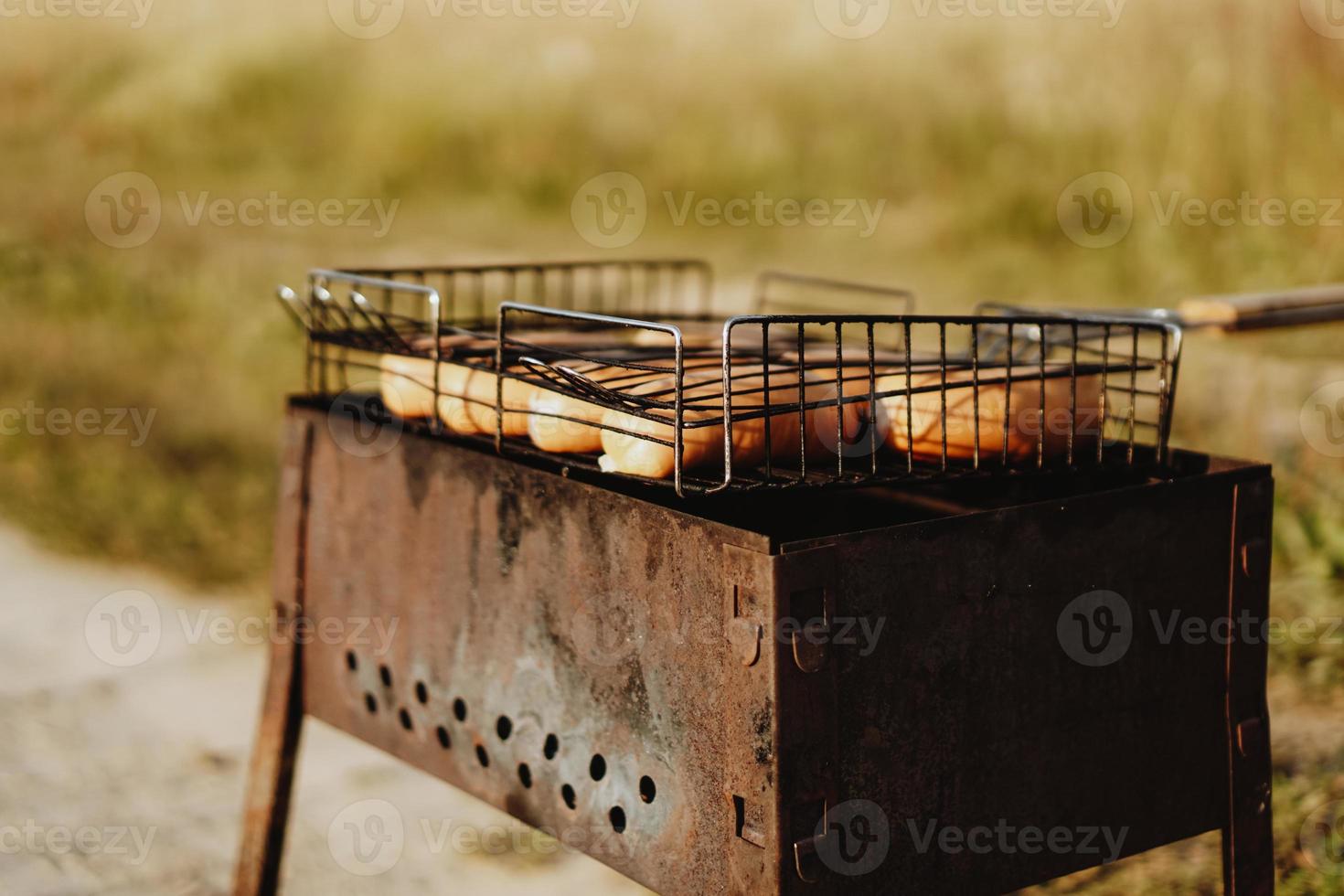 délicieuses saucisses grillées reposant sur la grille de fer photo