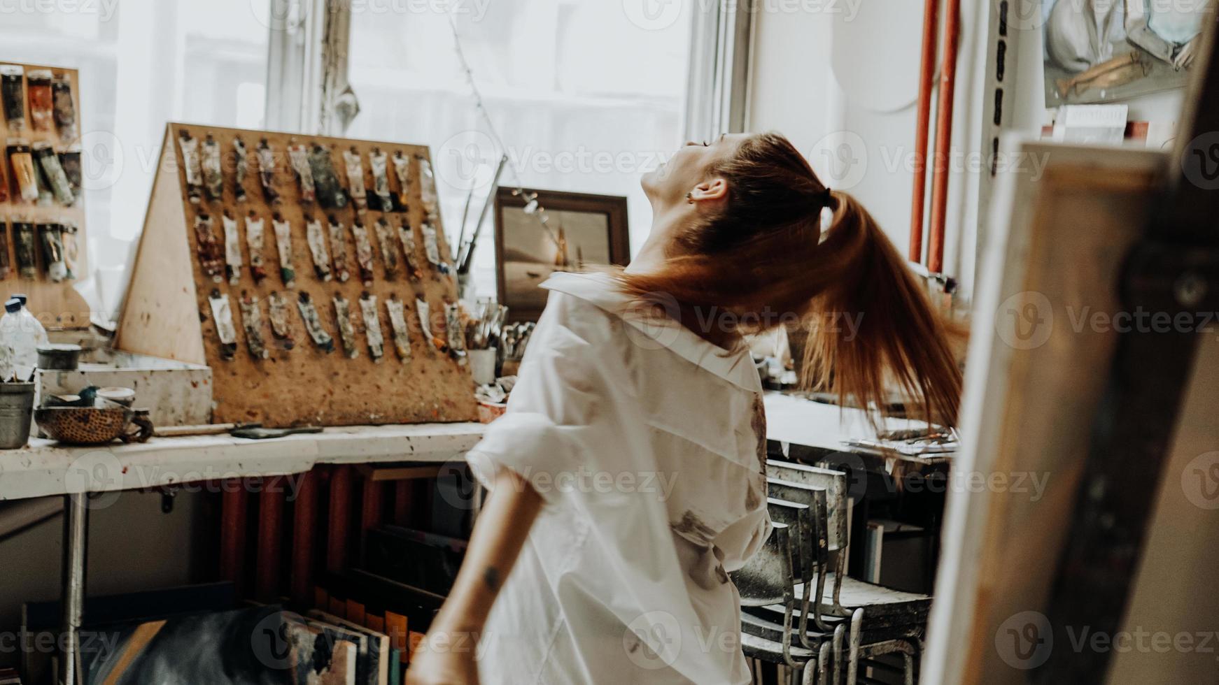 belle femme peintre dansant en peignant dans un atelier d'art photo