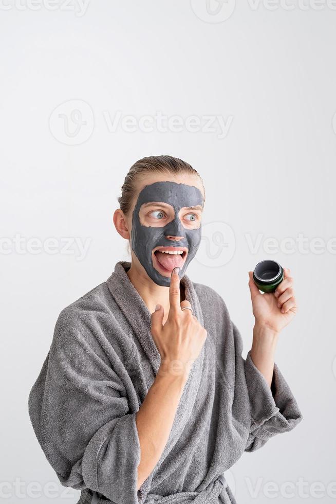 femme drôle heureuse appliquant un masque facial et l'essayant photo